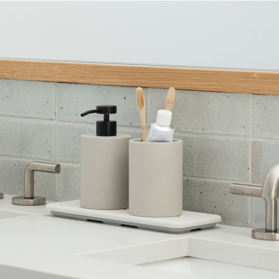 the small stone saucer with a vase and face cream on a beautiful bathroom vanity countertop