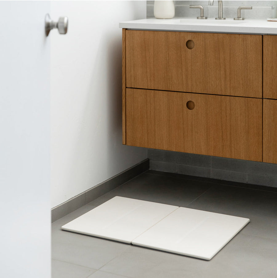 sandstone dual bath stone on floor of midcentury bathroom for cleaner and wet-free floors