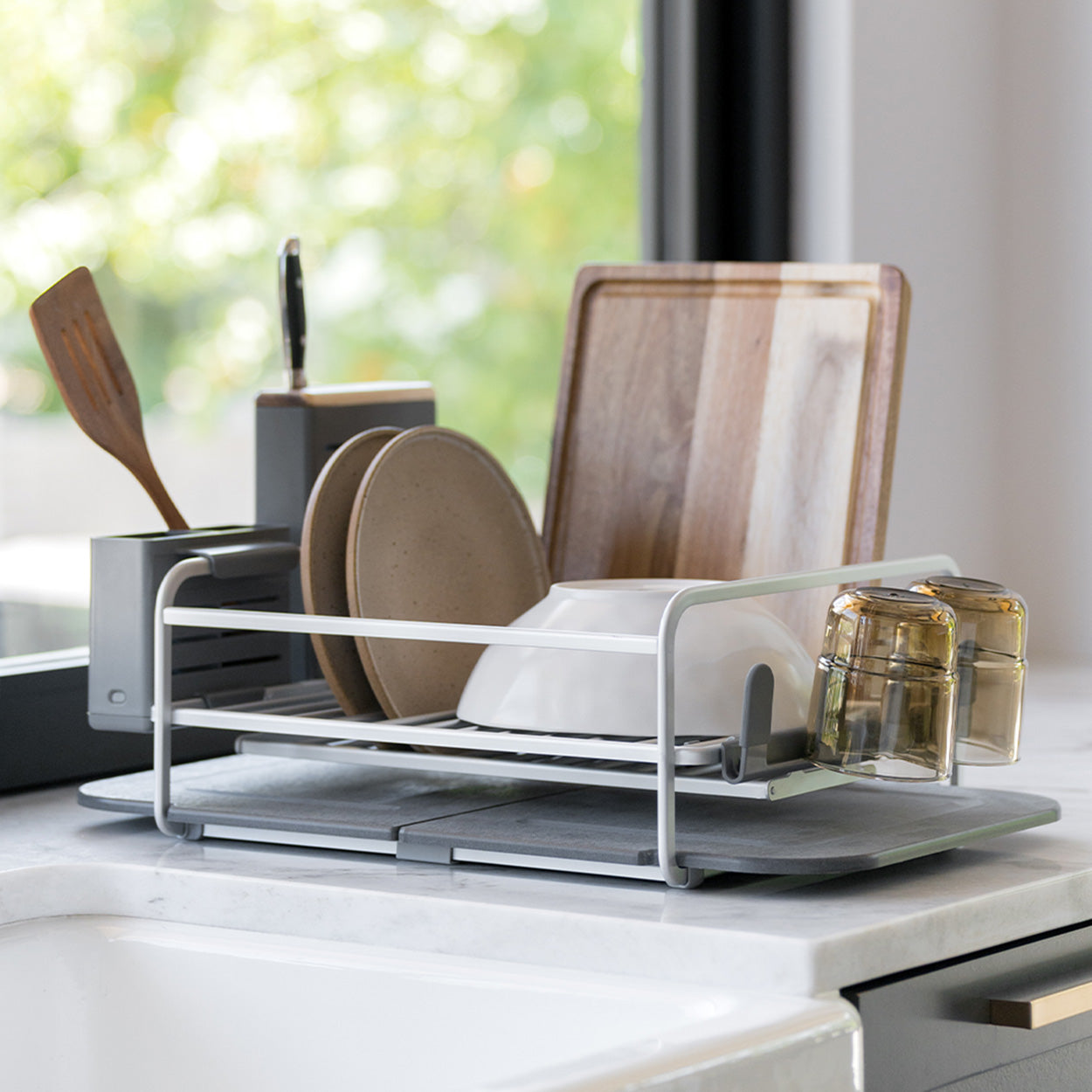 dish drying rack with dishes and glasses being dried