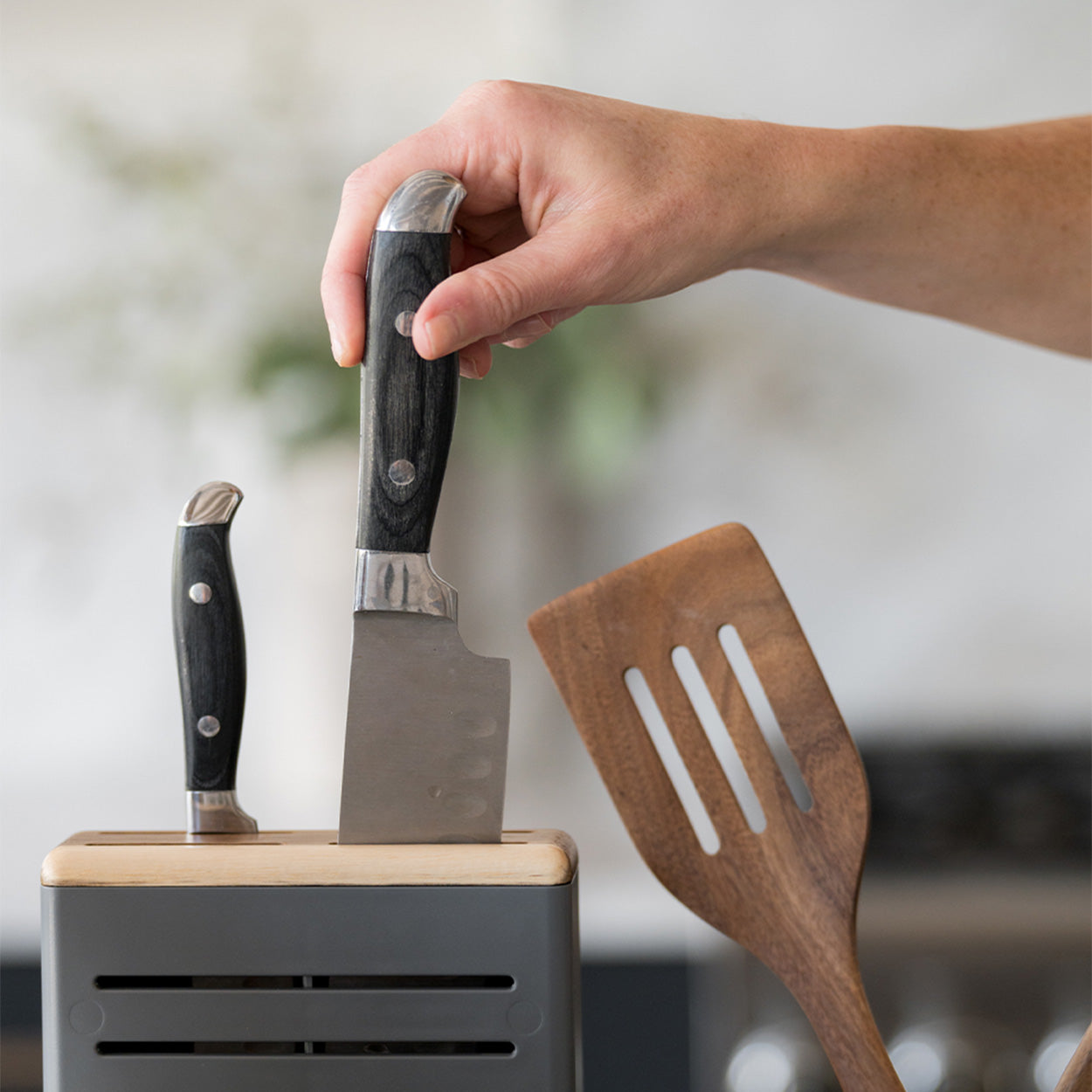 knife being inserted to knife holder with acacia knife holder