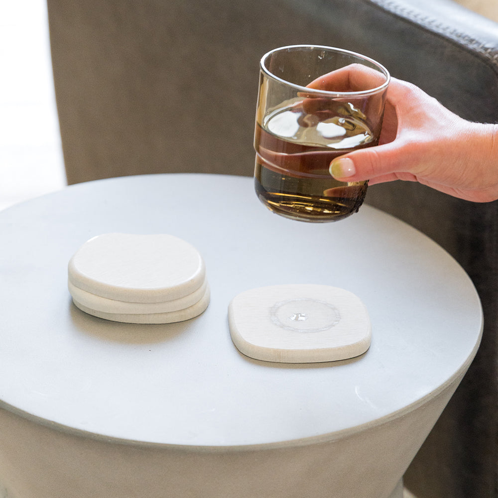 glass full of water being placed on stone coaster