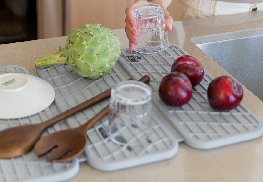 light grey dish pad with fruit and glasses being dried