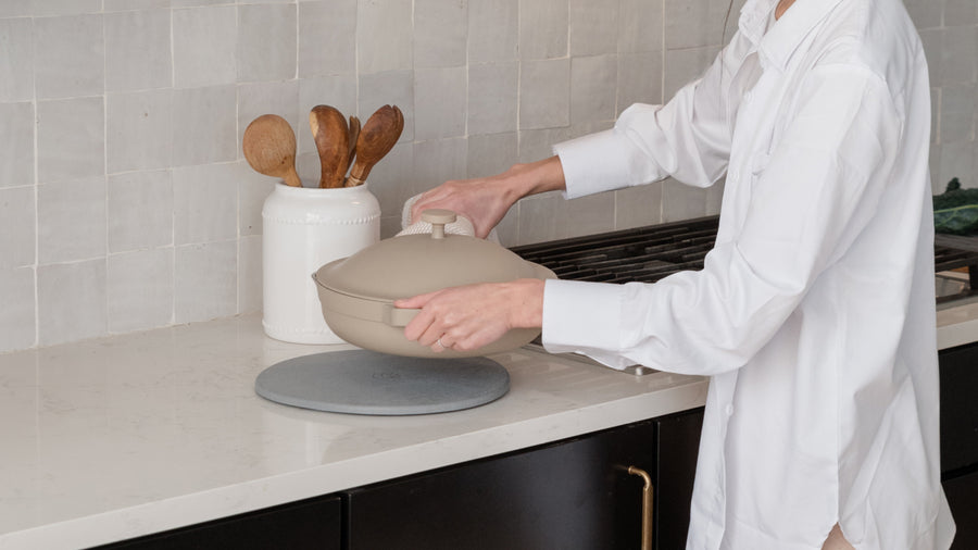 woman putting down pan on trivet