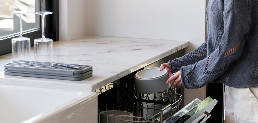 woman putting dog bowls into dish washer