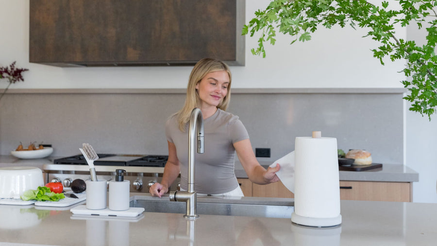 woman using weighted paper towel holder in kitchen - Dorai Home