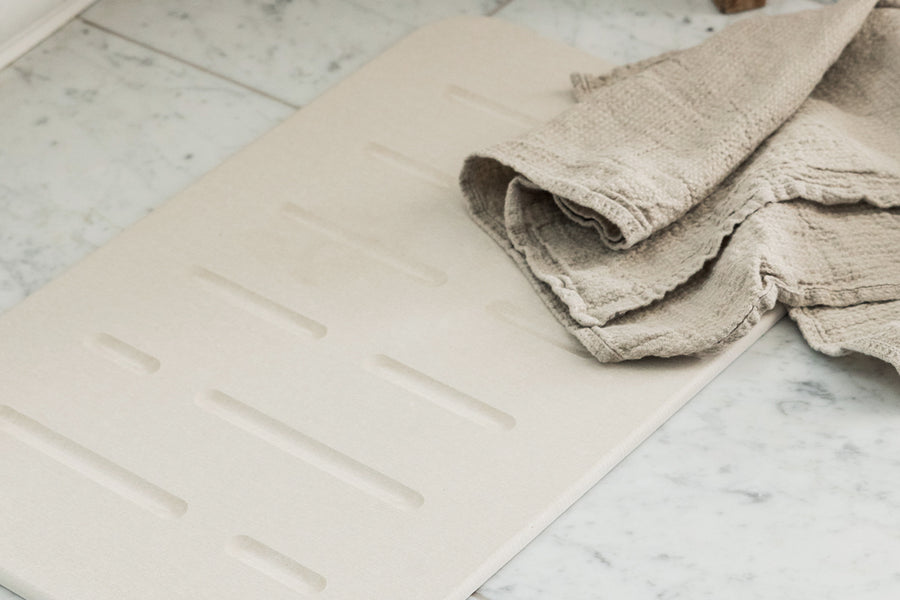 Dorai Bath Stone Mat Rain in Sandstone color, adding a stylish touch to a bathroom environment.