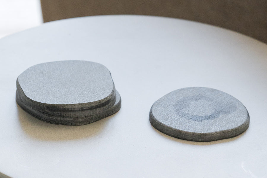 Dorai Slate-colored coaster, displayed on a clean surface, with a focus on its minimalist design.