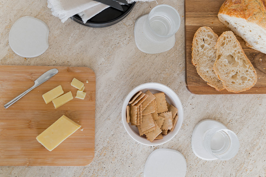 Dorai coaster in Sandstone color, placed on a table surface, showcasing its simple design.