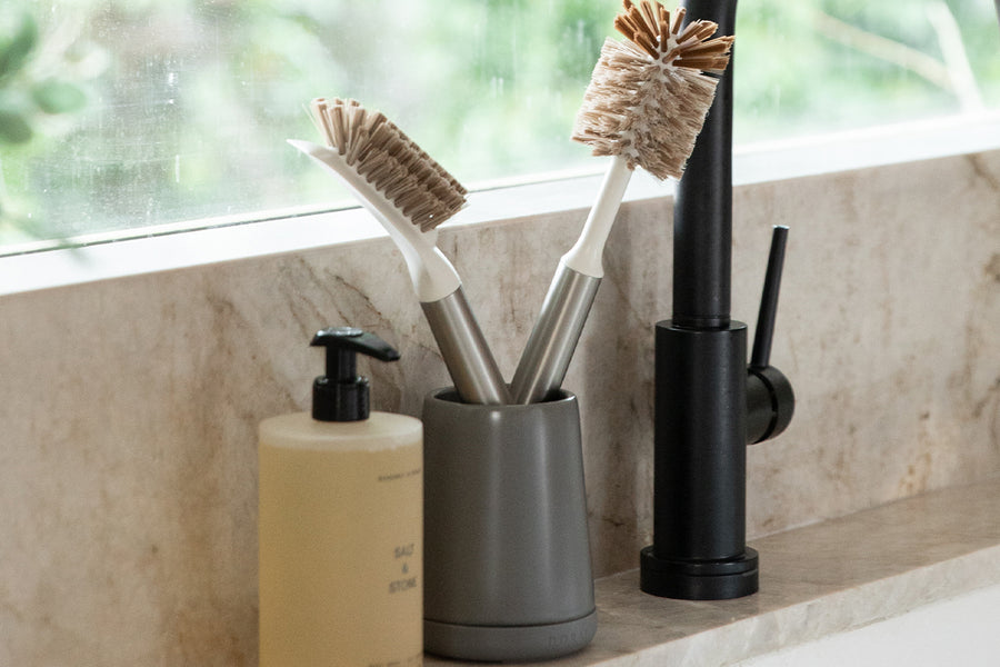 Dorai Brush Holder in Slate color, holding kitchen brushes, placed on a kitchen counter.