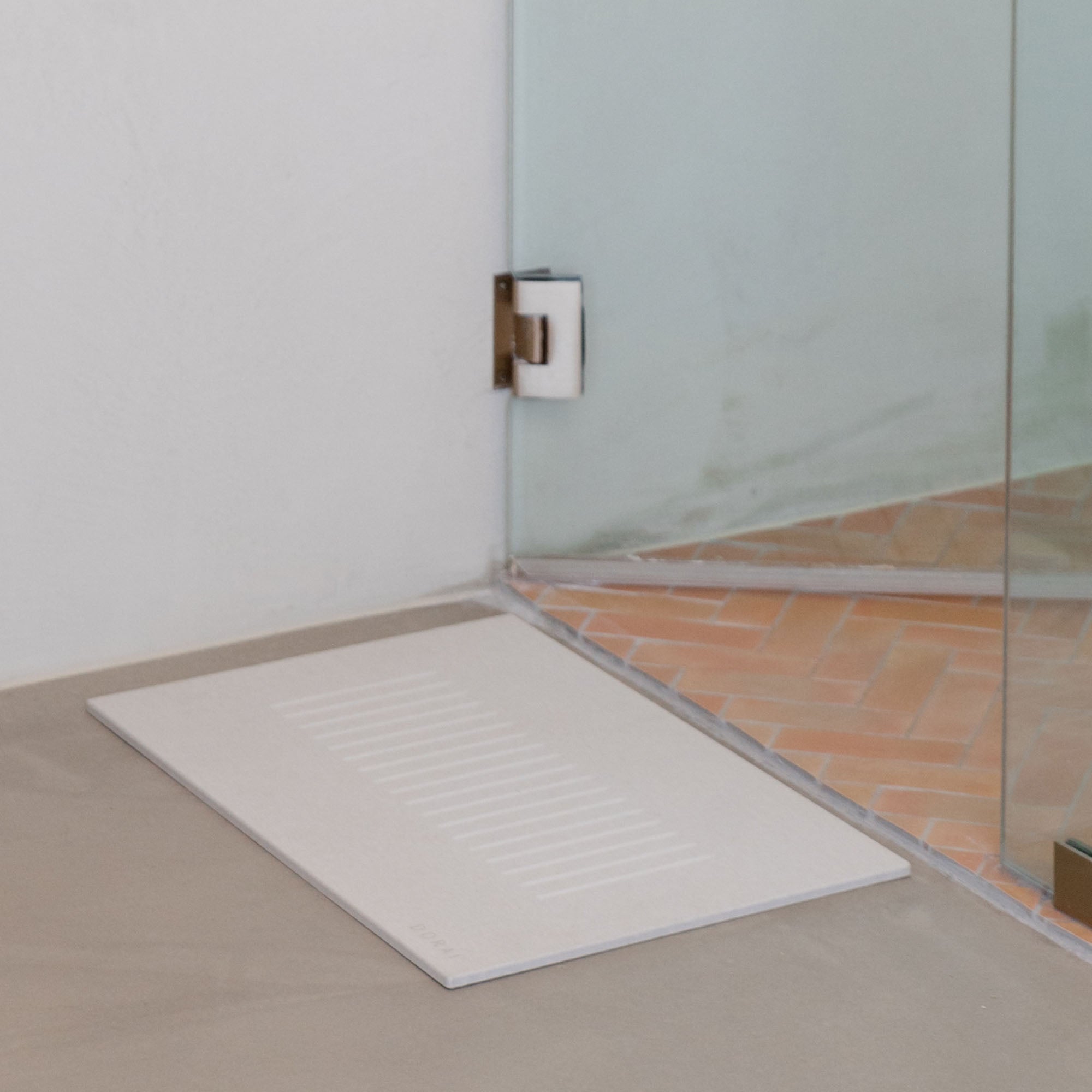 Original bath stone in Sandstone in front of shower in minimal bathroom