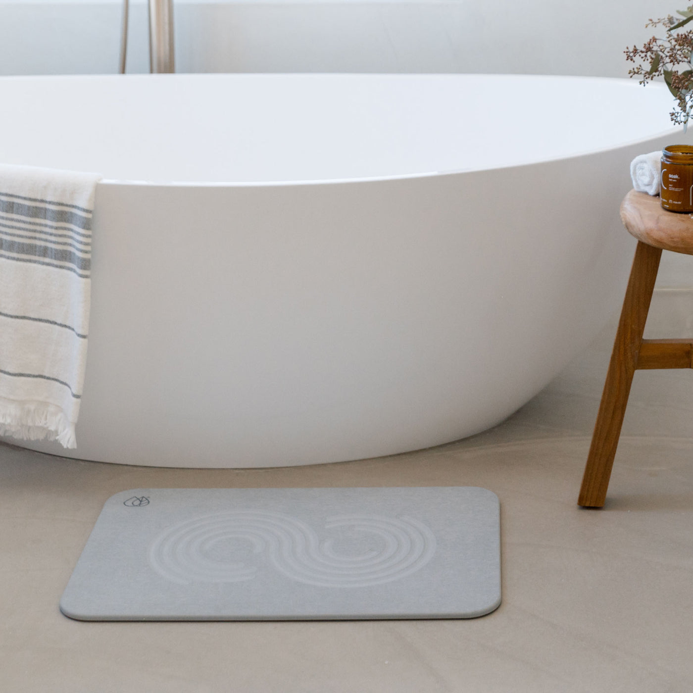 Original bath stone in Ash in front of free-standing tub in minimal bathroom