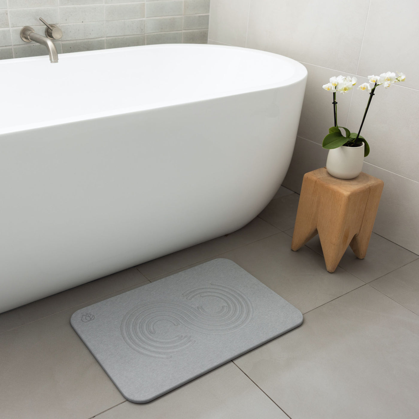 Original bath stone in Ash in front of free-standing tub in modern bathroom