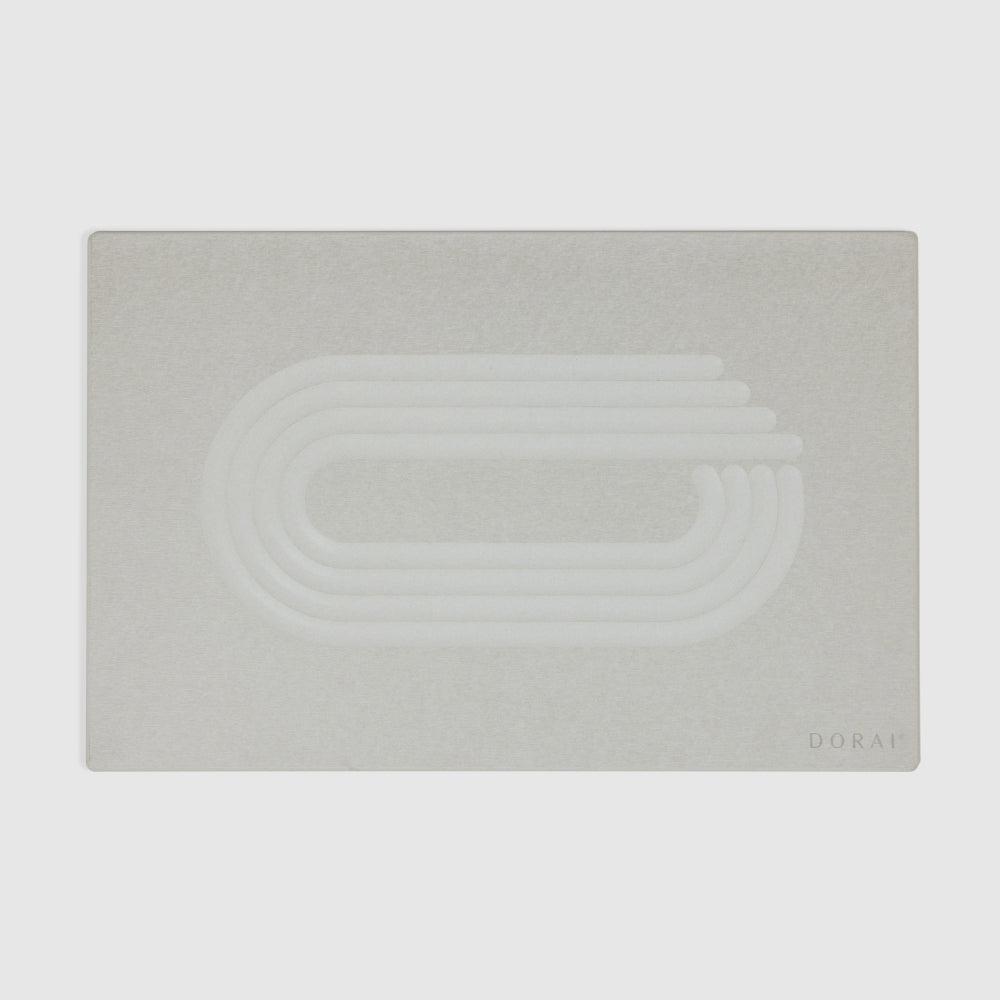 of white bath mat with textured pattern on a light gray background