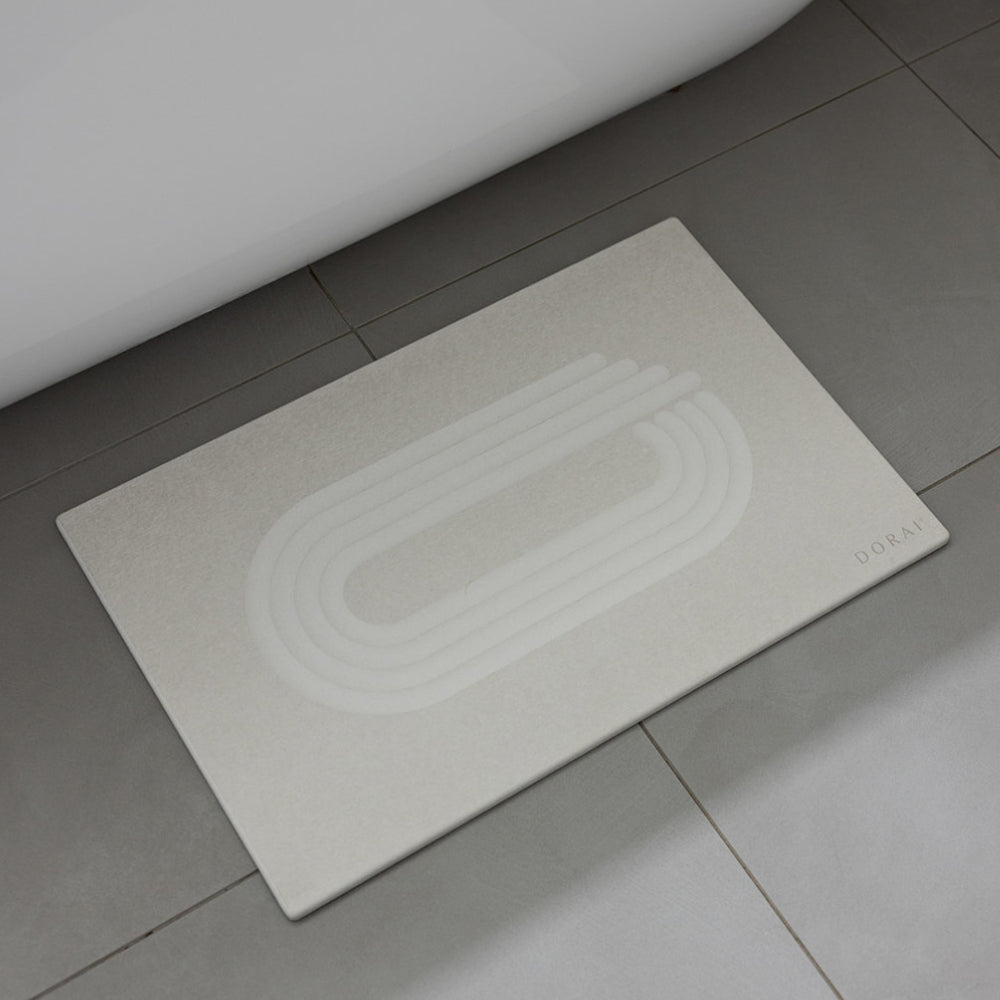 of white bath mat on a tiled bathroom floor