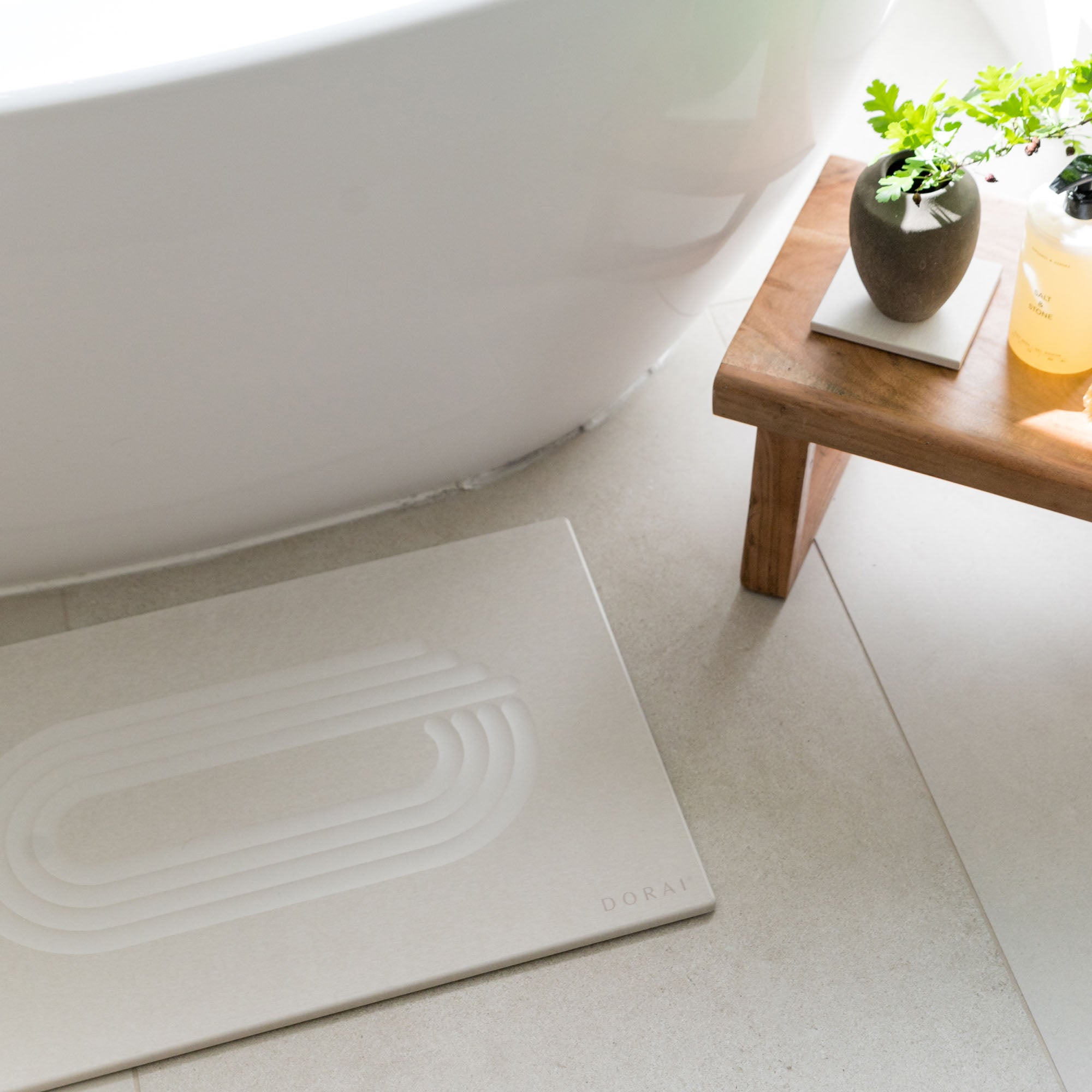 Original bath stone in Sandstone in front of free-standing tub in minimal bathroom