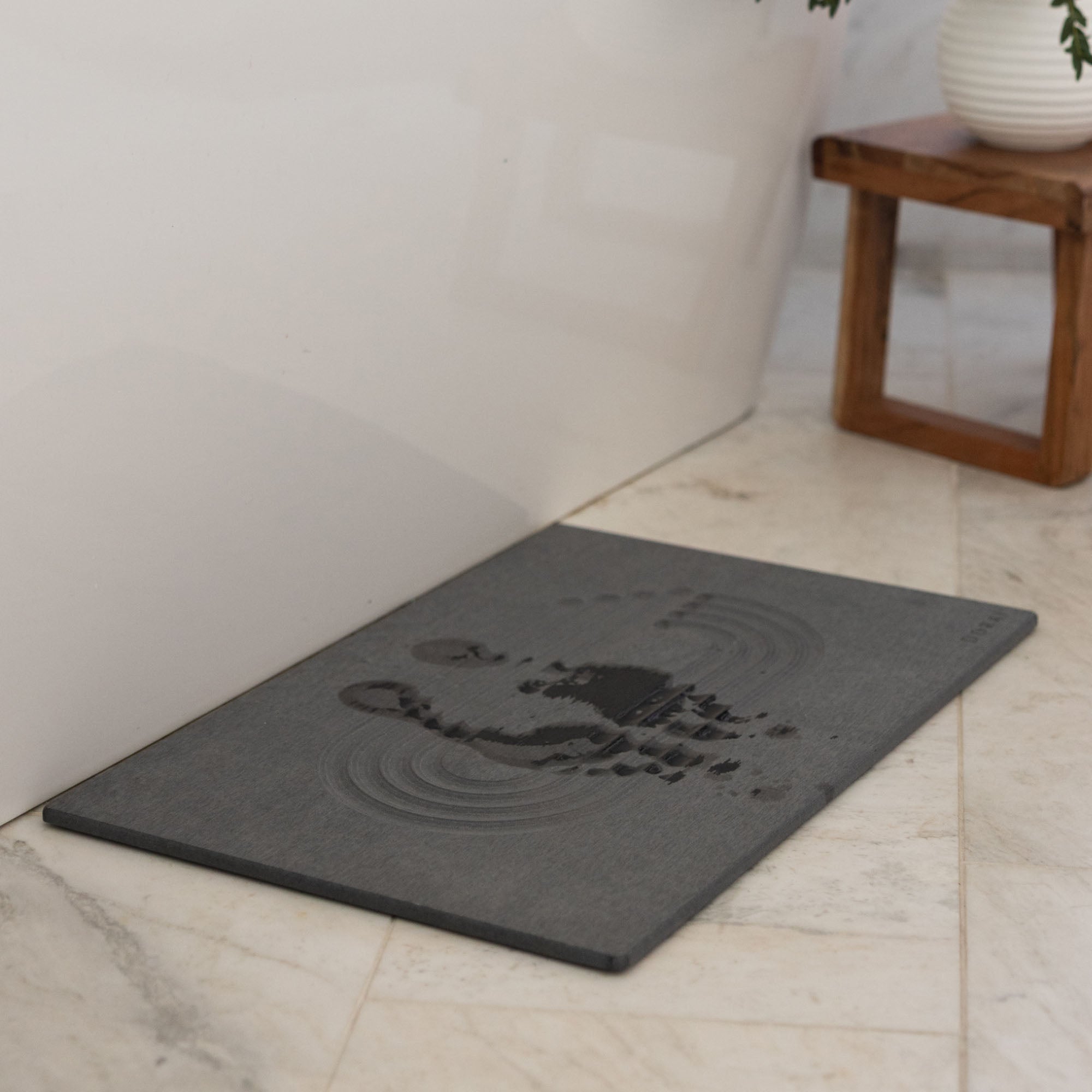 Original Current bath stone in Slate quickly absorbs water from wet feet in bathroom. 