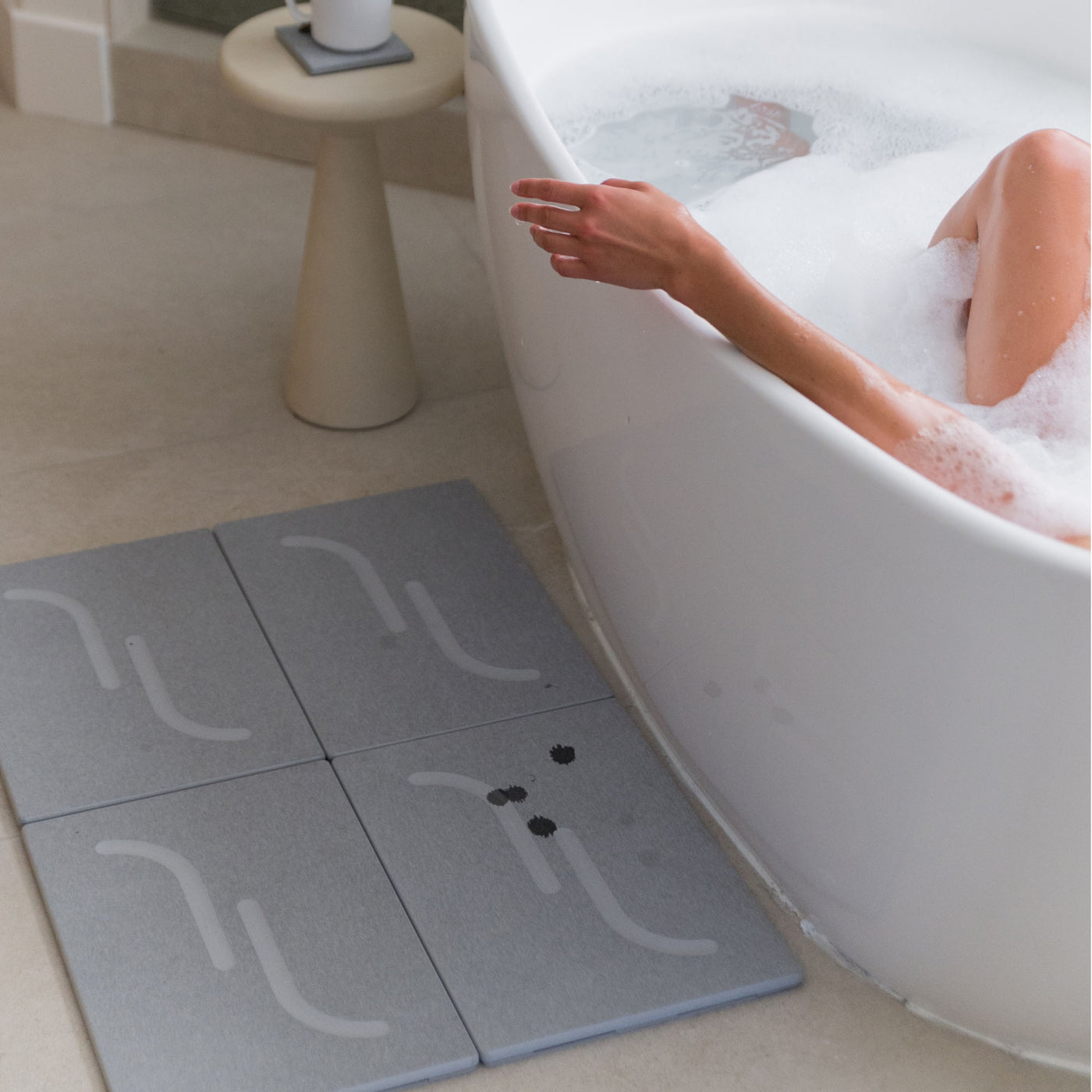 Large Arch Bath Stone in Ash in modern bathroom with water drops that dry quickly.