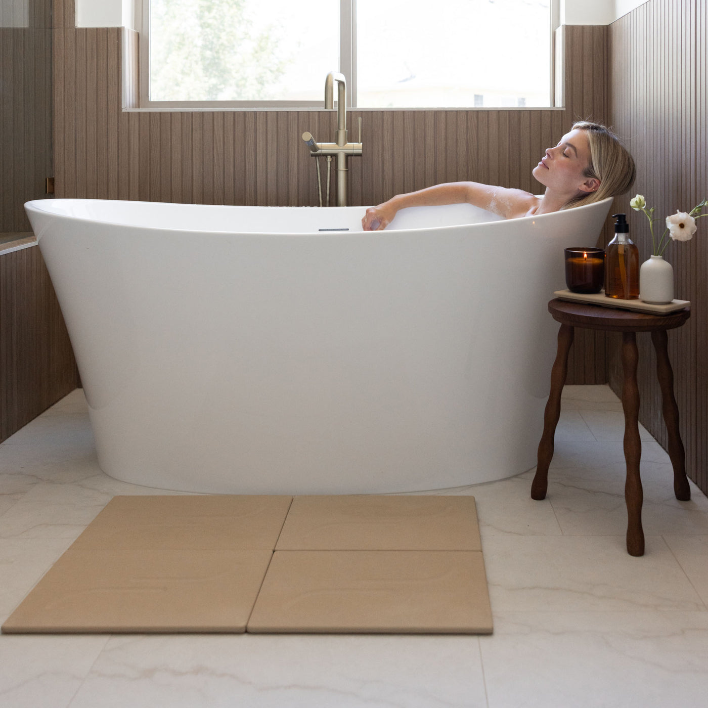 Clay Alta Large Bath Stone Mat in front of large, free-standing tub.