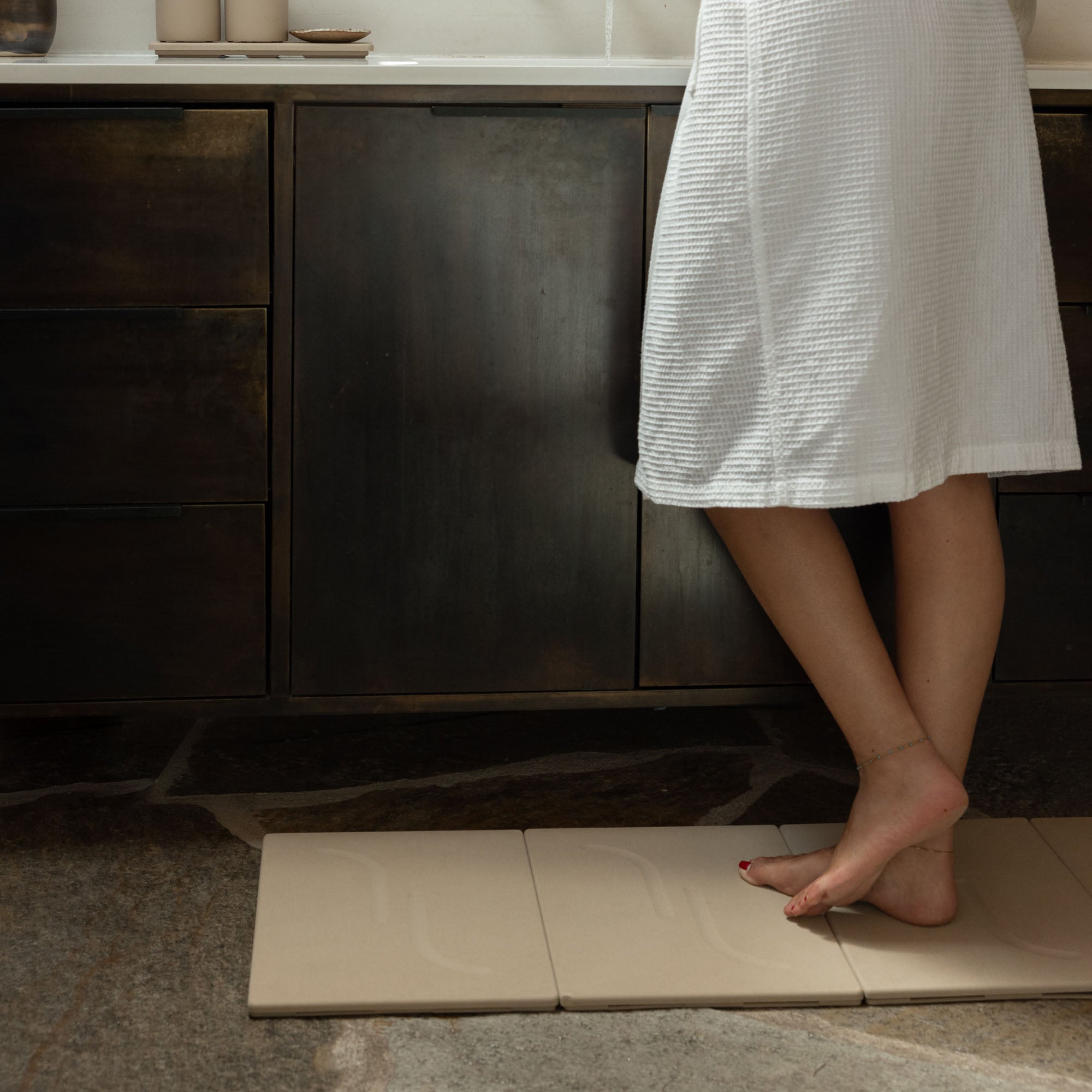 Clay Alta Large Bath Stone Mat in 4 sections in front of vanity.