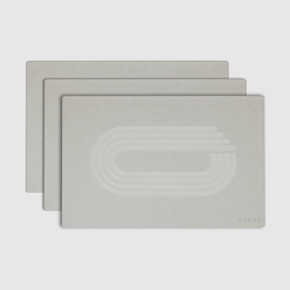 Three of white shower mats with a logo on a light gray background

