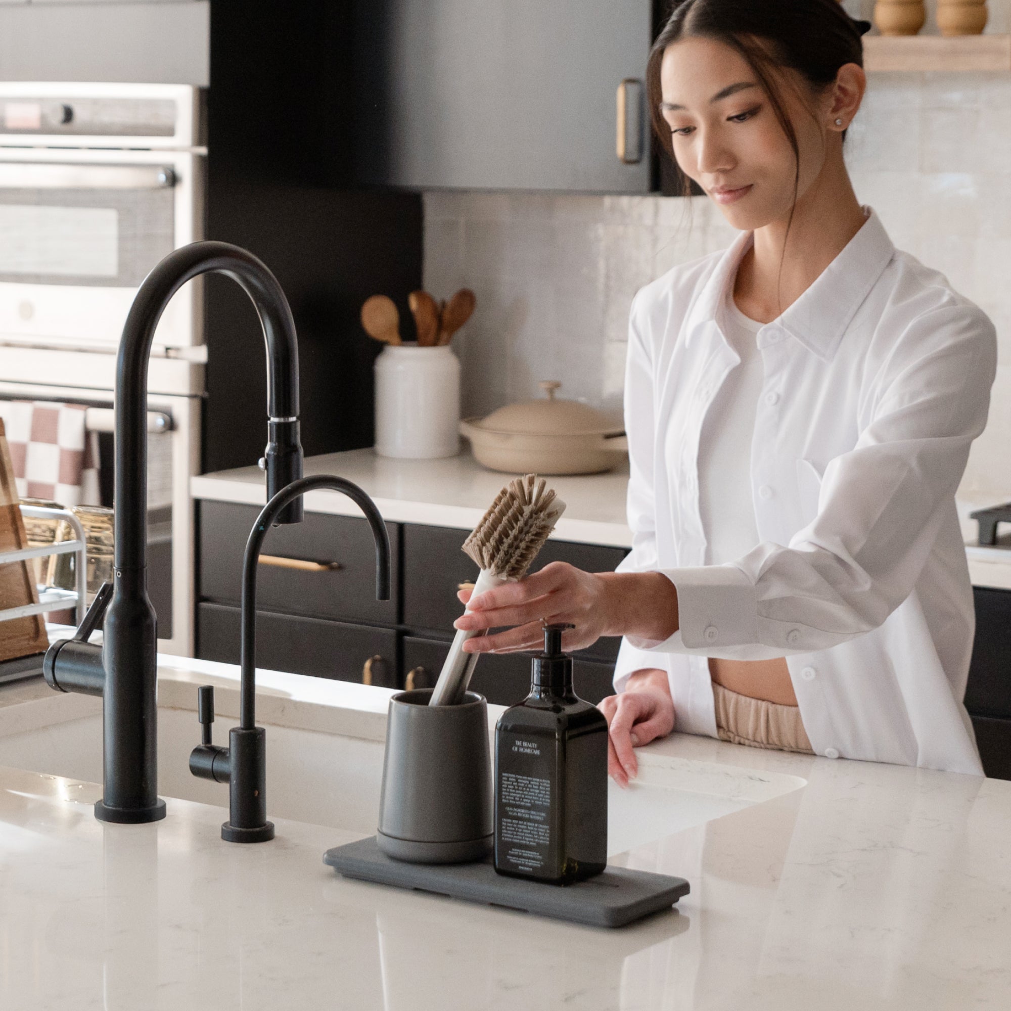 woman inserting brush into brush holder in kitchen