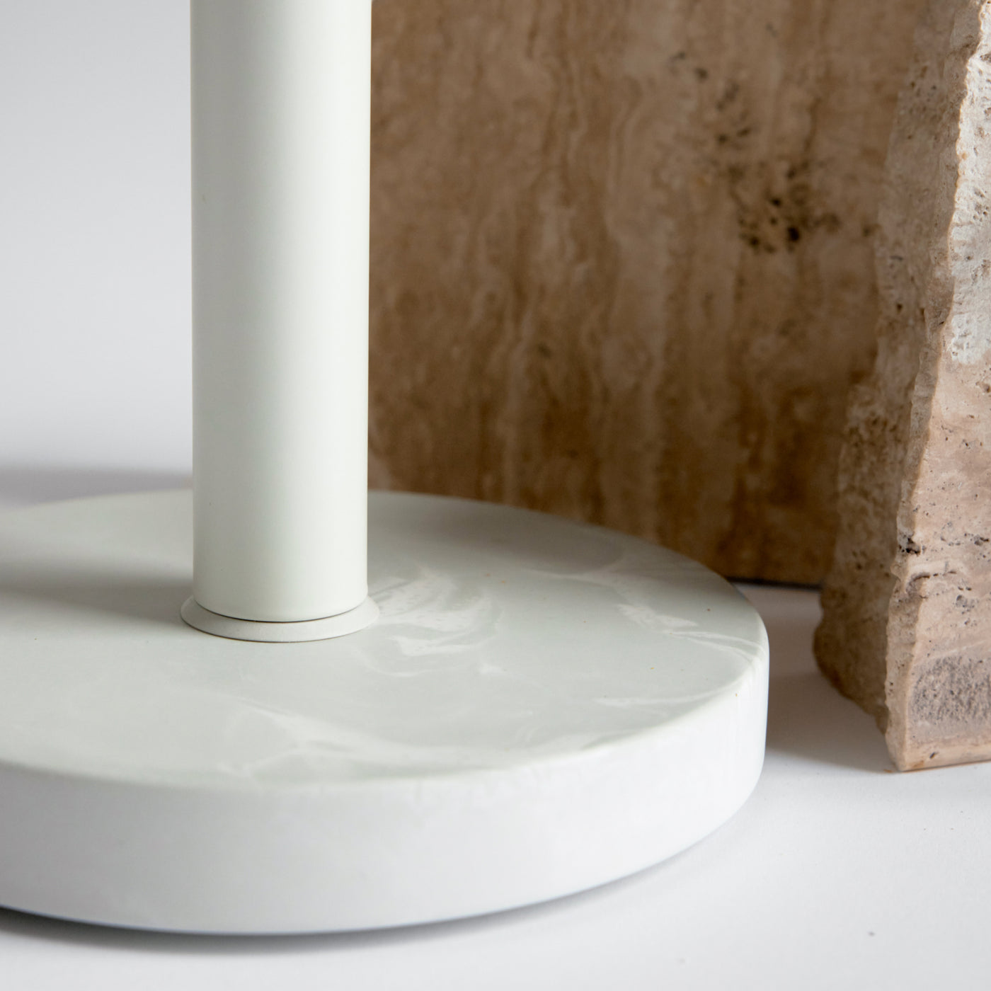 detail of paper towel holder with rock in the background