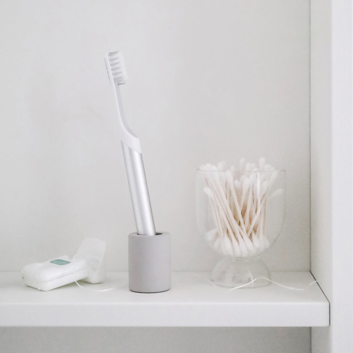 Light Gray Small Toothbrush Holder with small electric toothbrush in cabinet. 