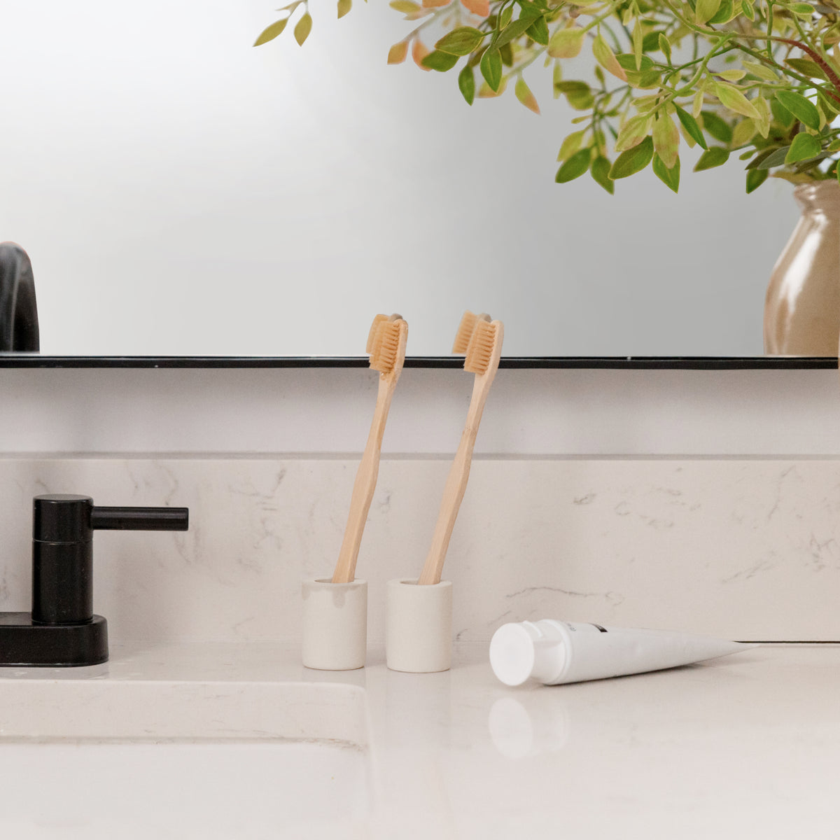 Soft Beige Small Toothbrush Holder with two small toothbrushes in bathroom. 
