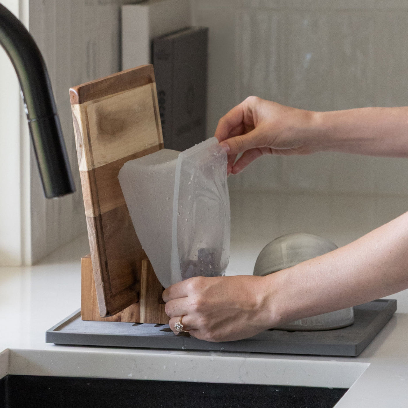 Placing bag to dry on Acacia Cutting Board Holder while washing dishes.