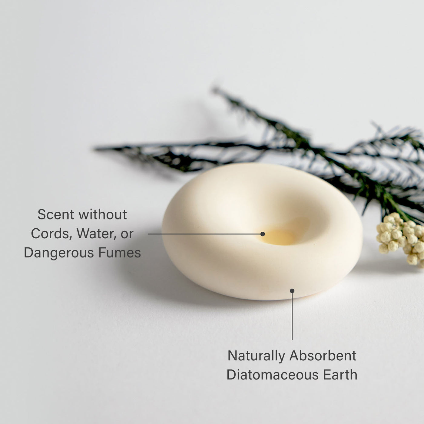 Scent stone with essential oil in it with text highlighting features on a light gray background