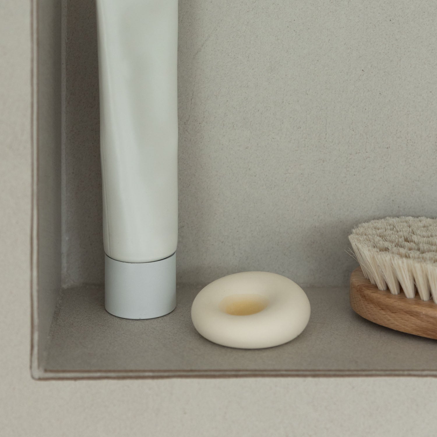 scent stone with essential oil in it on a shower shelf