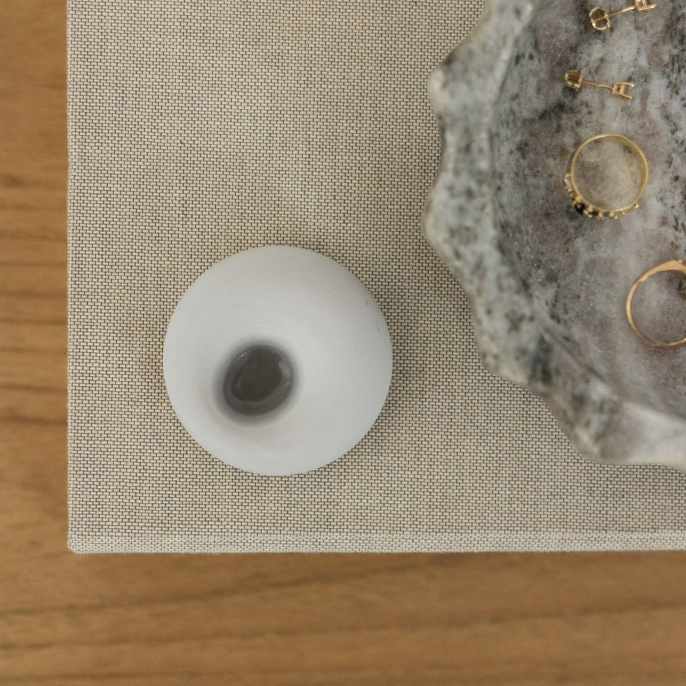 Scent stone with essential oil on a desk with a ring dish next to it