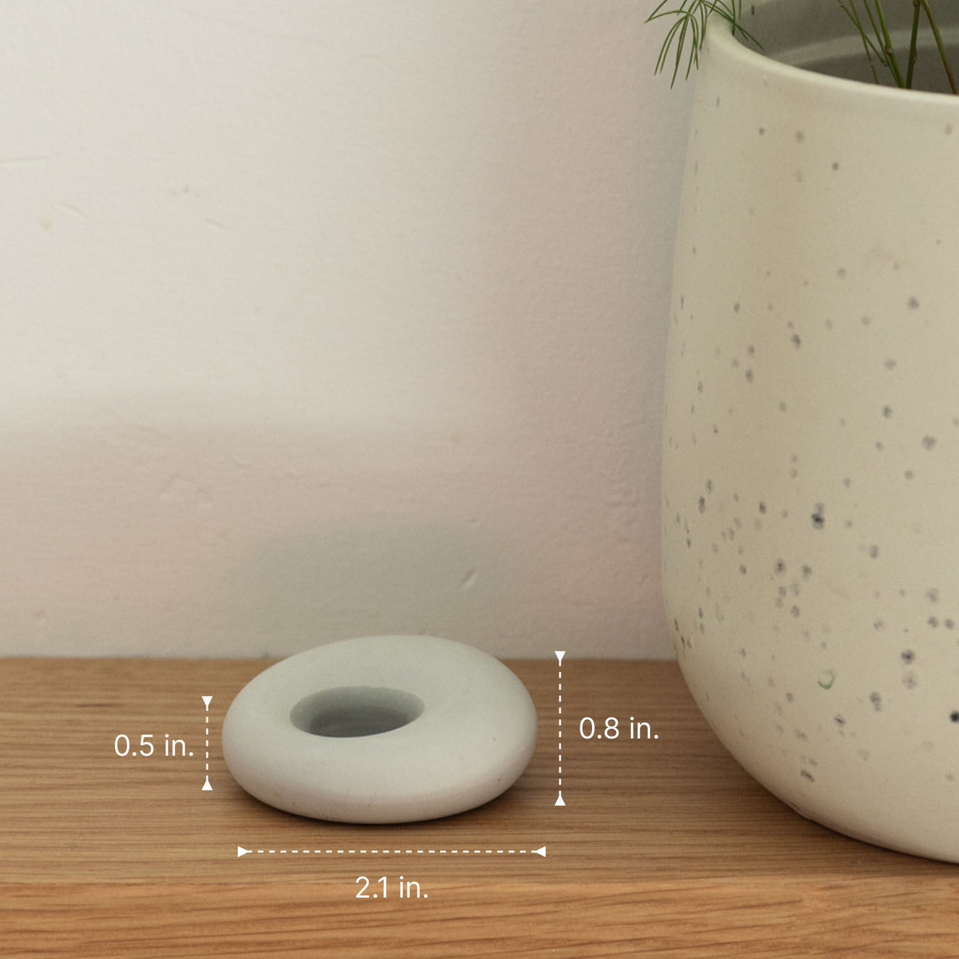 scent stone on a wooden shelf with measurements, next to a larger ceramic pot.