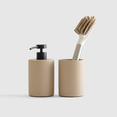 Taupe soap dispenser and brush holder on white background.