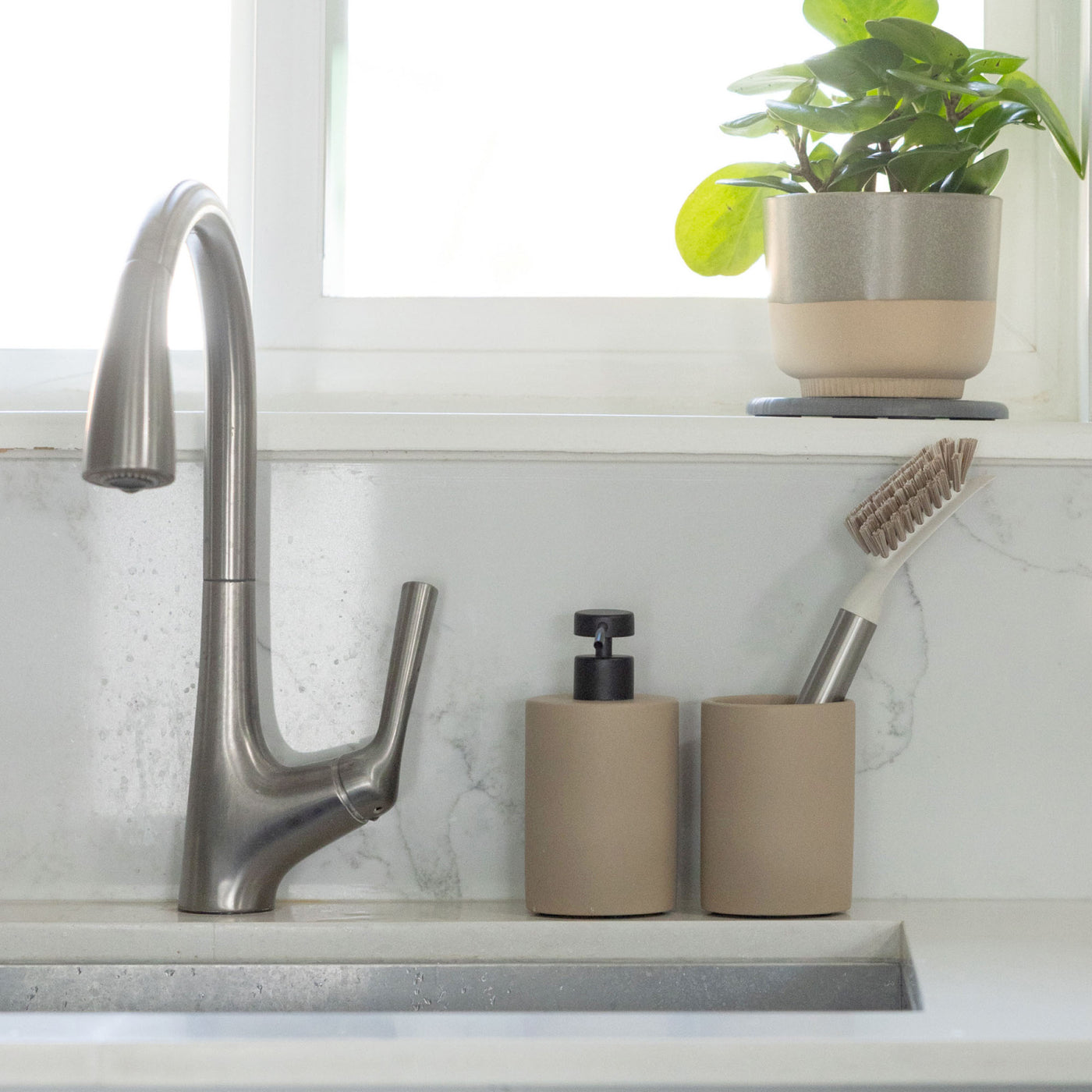 Taupe sink holder and brush set in modern kitchen.