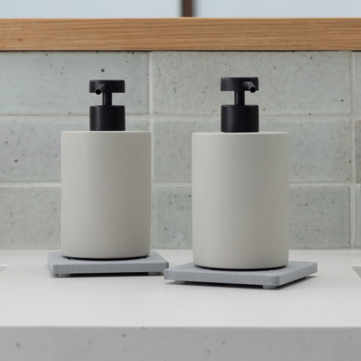 Two Ash Soap Caddy with Concrete Soap Dispensers in bathroom.