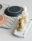 Sandstone dish pad with plates on it and sandstone sink caddy with scrubber and soap