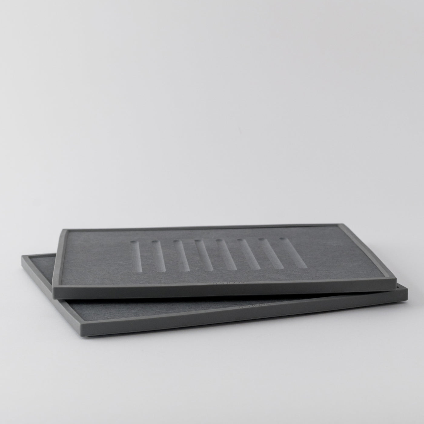 Two grey dish drying mats stacked on a light gray background