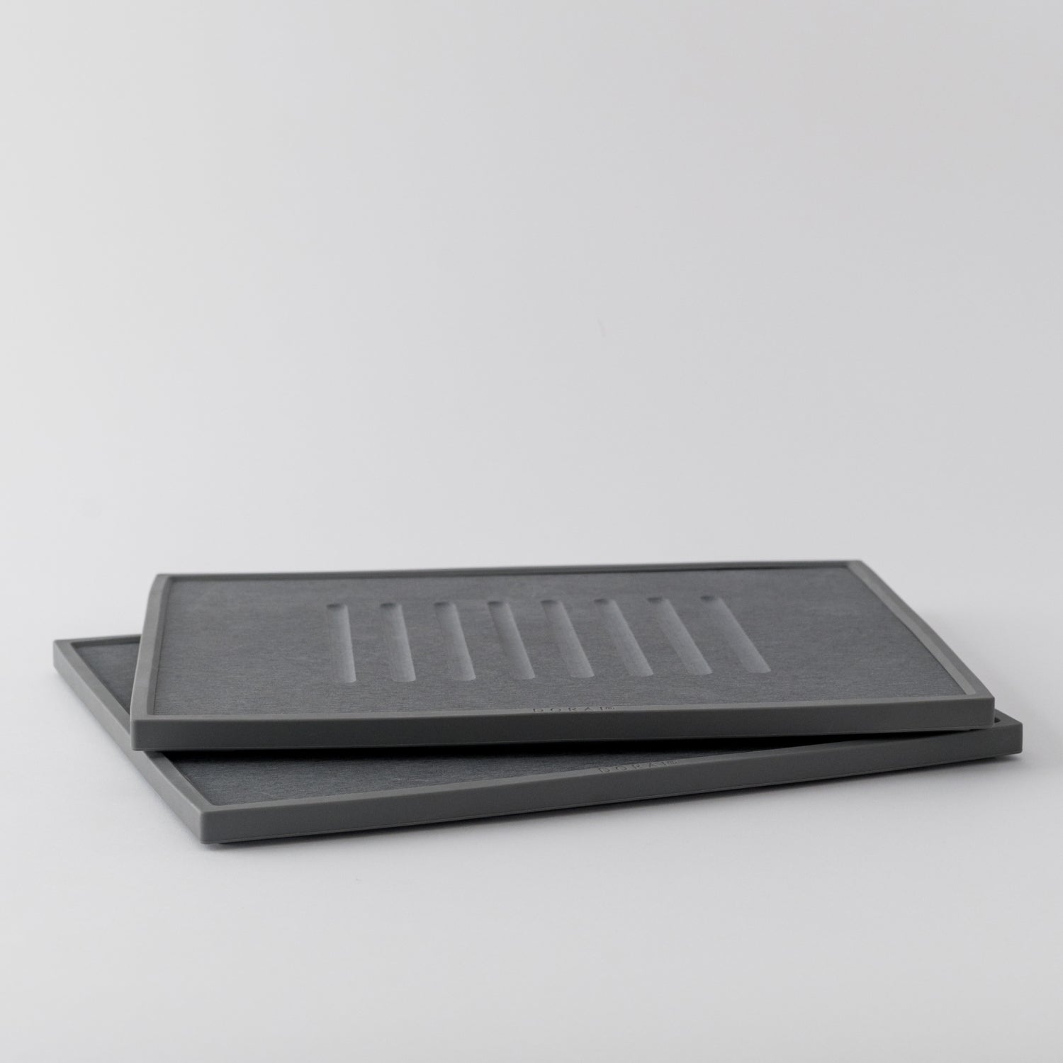 Two grey dish drying mats stacked on a light gray background