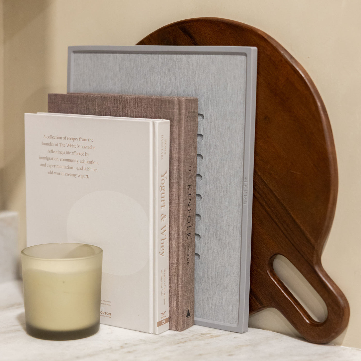 Beautiful kitchen with neutral cookbooks and ash dish drying stone. 