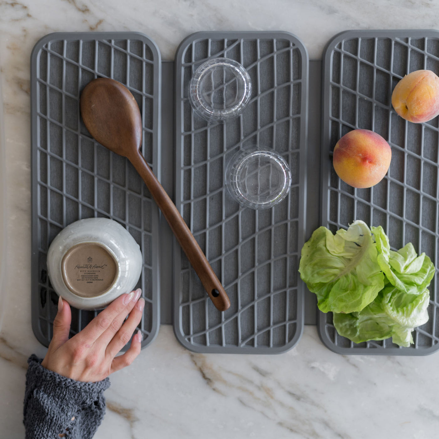 Gray silicone mats with kitchen items on a marble countertop
