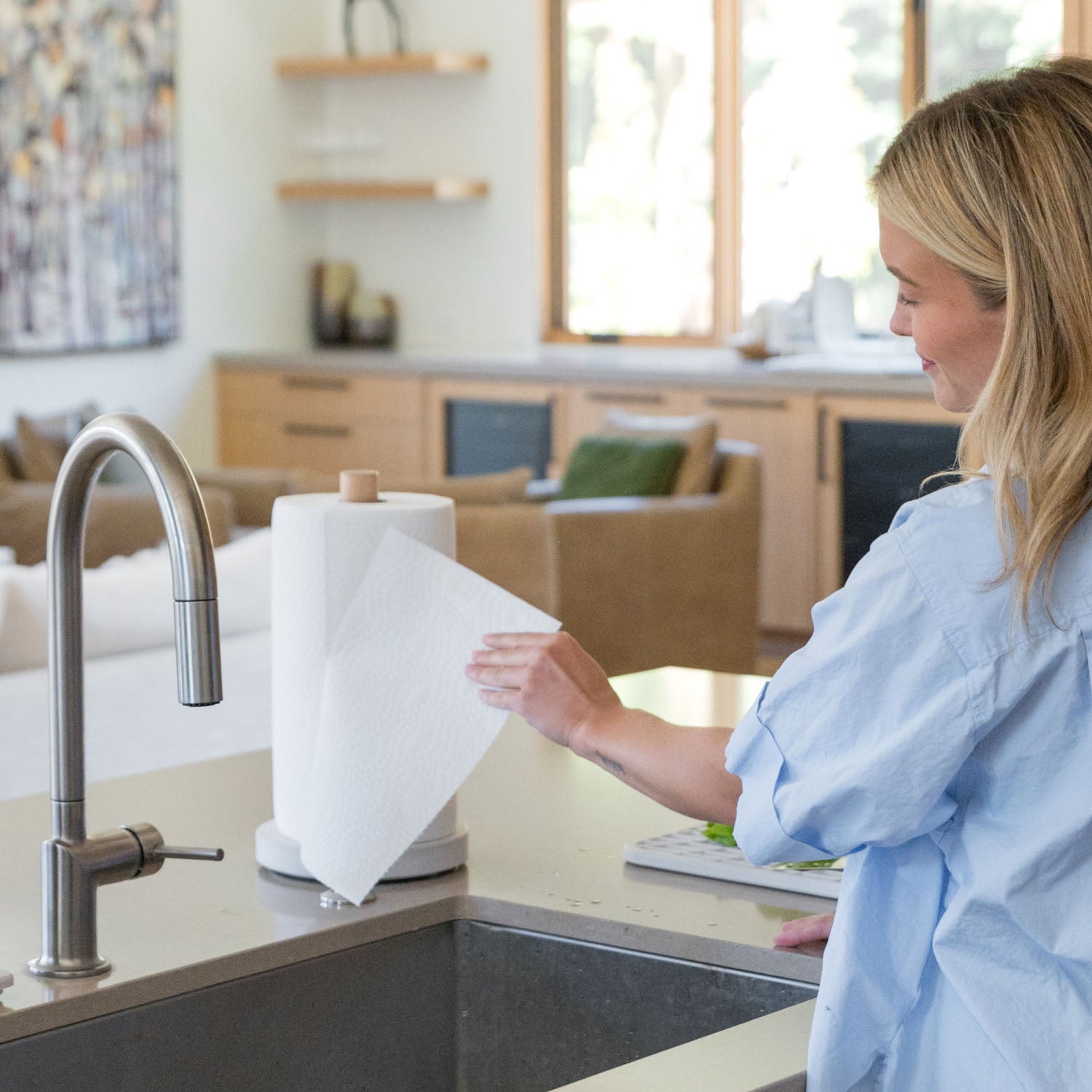 Woman using a paper towel at a kitchen sink