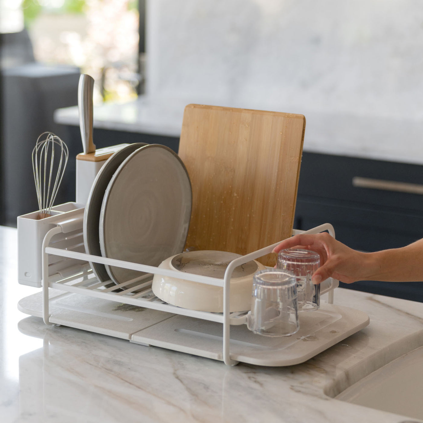 Dish drying rack with dishes on a kitchen counter