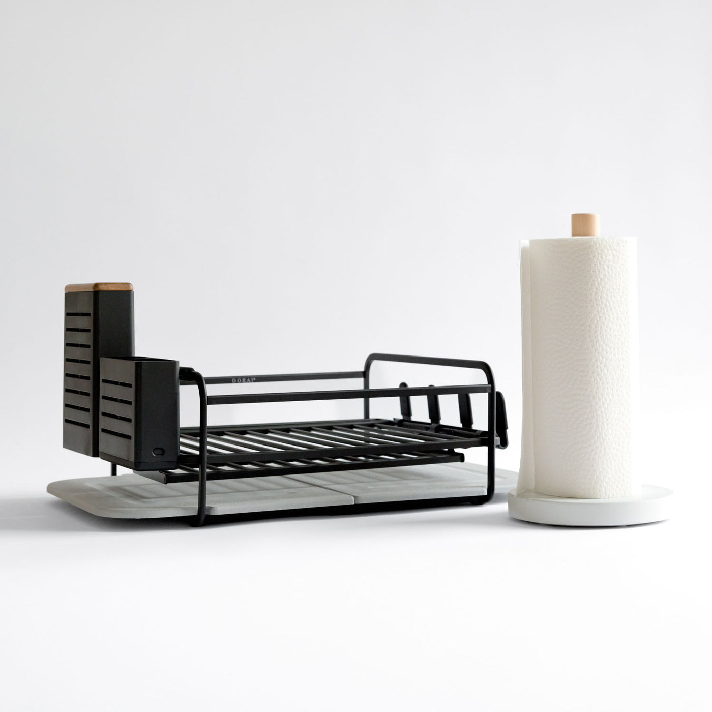 black dish drying rack with white paper towel holder as kitchen set