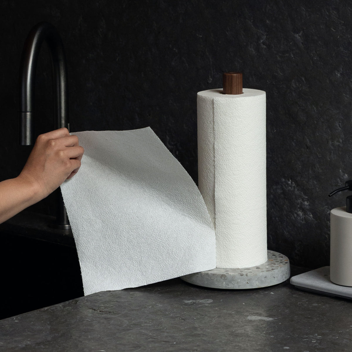 Easily ripping a paper towel with one hand on the Basalt Paper Towel Holder. 