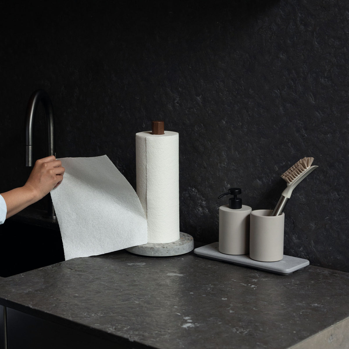 Ripping Basalt Paper Towel Holder with one hand in beautiful kitchen. 