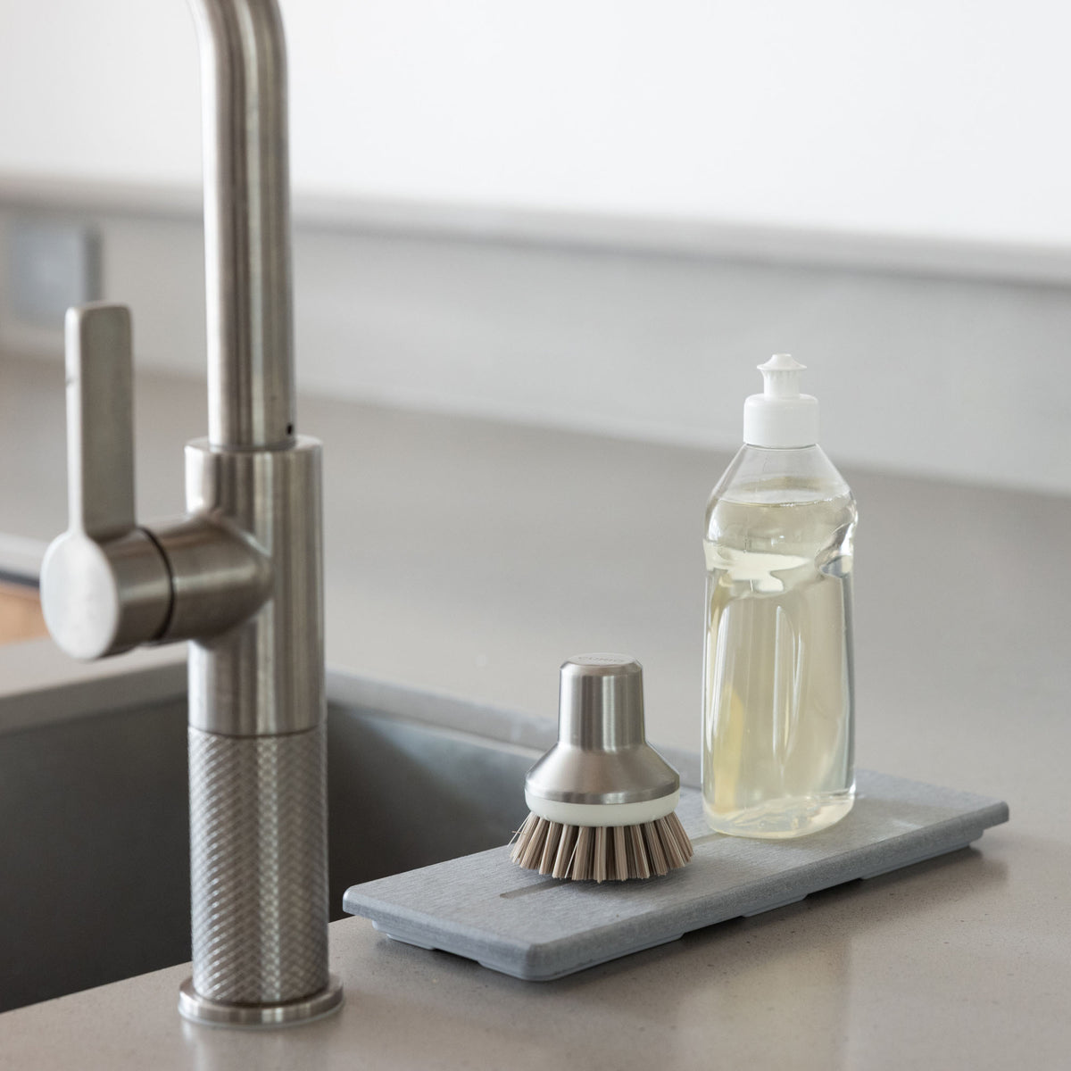 Water quickly drying on Ash Stone Sink Caddy with soaps. 