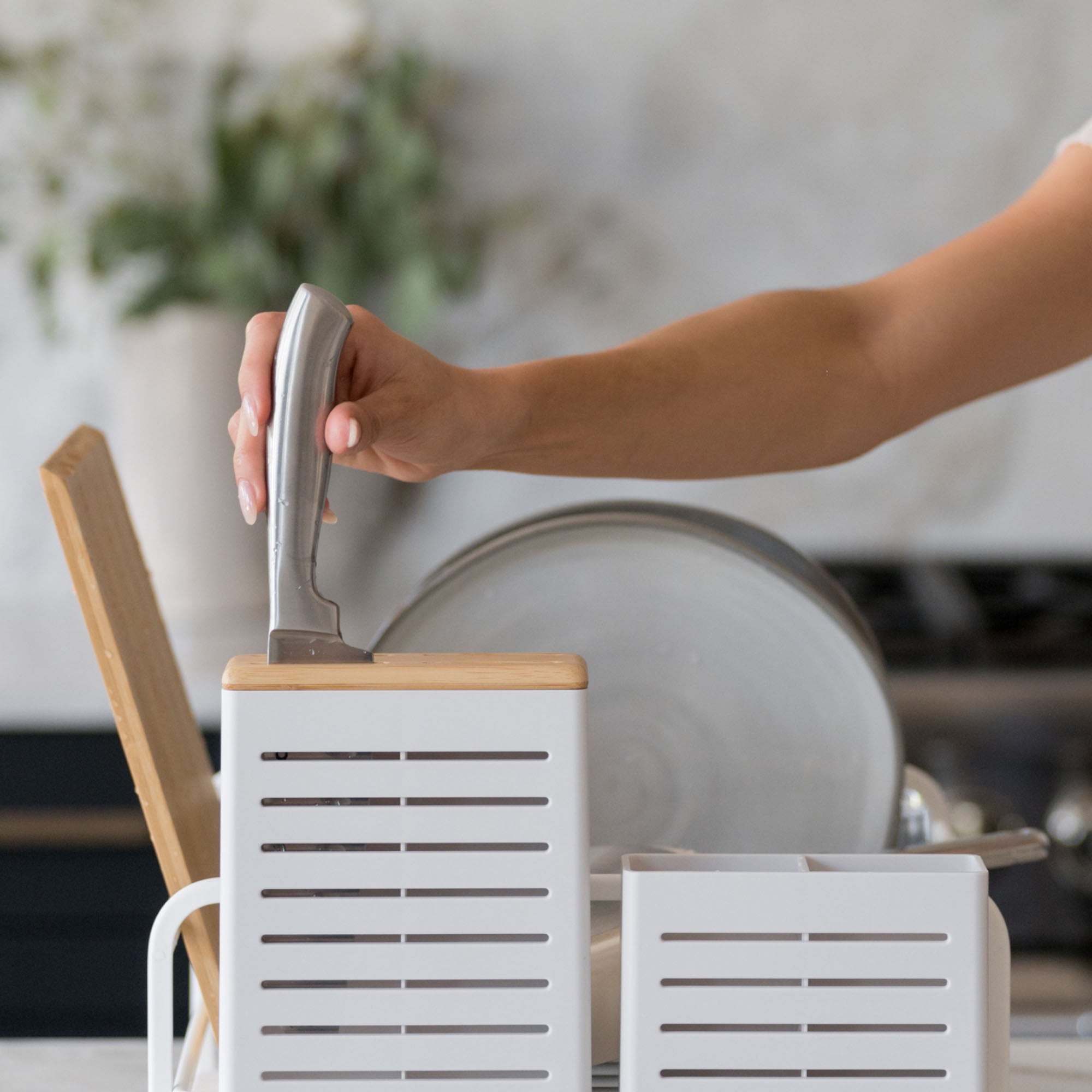 Knife being placed into knife holder on Glacier Dish Rack. 