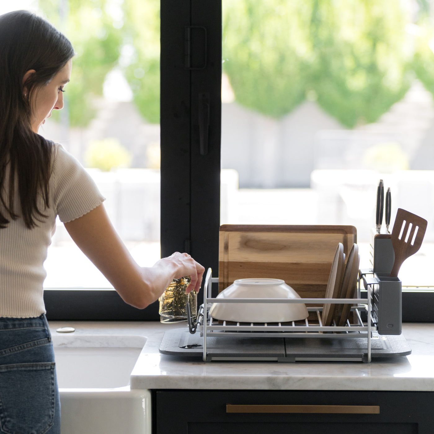 Woman putting away dishes on Slate Dish Rack in beautiful, modern kitchen.