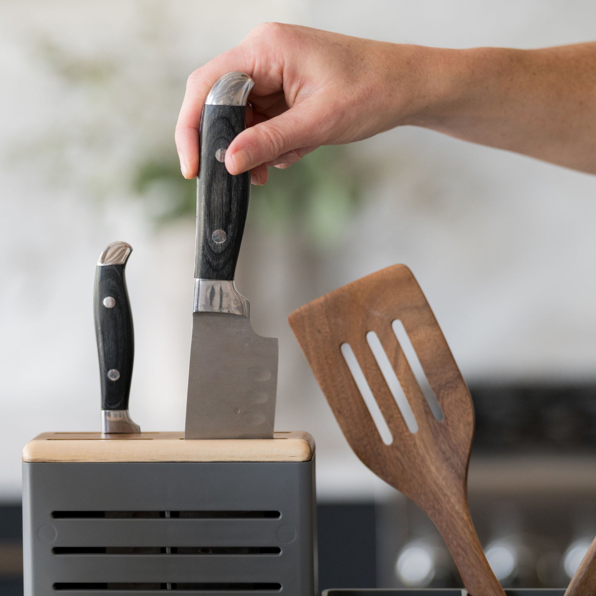 Knife being put away in knife holder in modern slate dish rack.